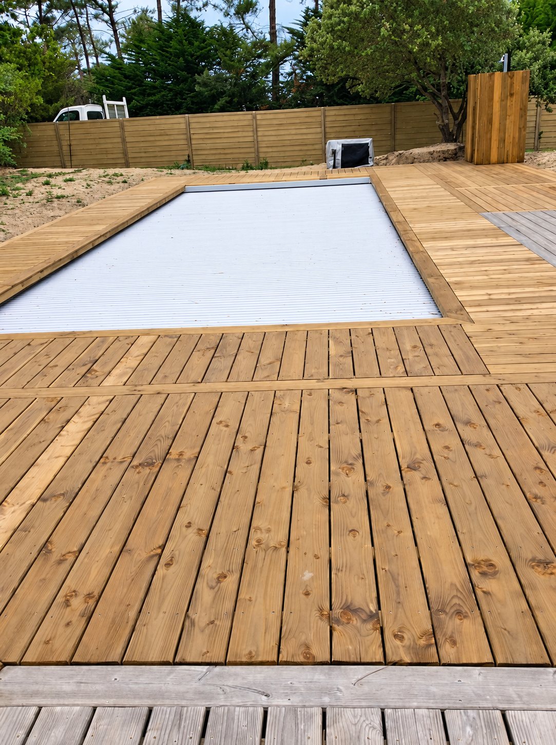 Piscine avec volet roulant et terrasse en bois